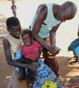 A child's finger being marked to show that he has been vaccinated for measles